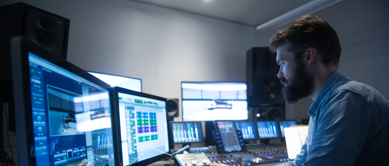 A recording engineer working in a modern digital recording studio at Voxman Music Building