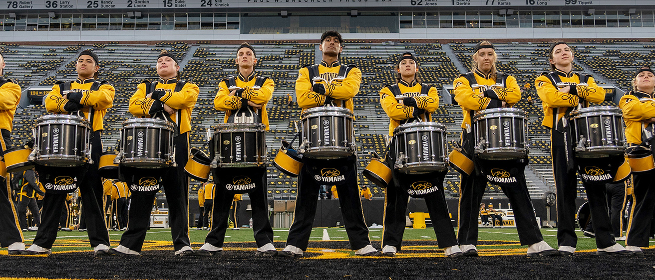 Band Extravaganza promo image of band members in black and gold uniforms