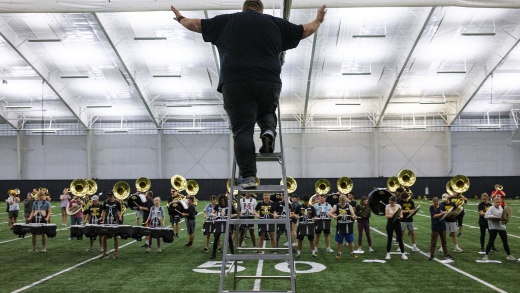 Graduate teaching assistant and doctoral student Drew Bonner conducts Oct. 26 during a Hawkeye Marching Band practice at the Hawkeye Tennis and Recreation Complex in Iowa City. (Nick Rohlman/The Gazette)