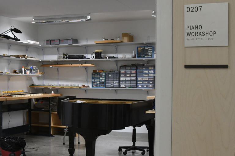 A view of a piano workshop including shelves and tools
