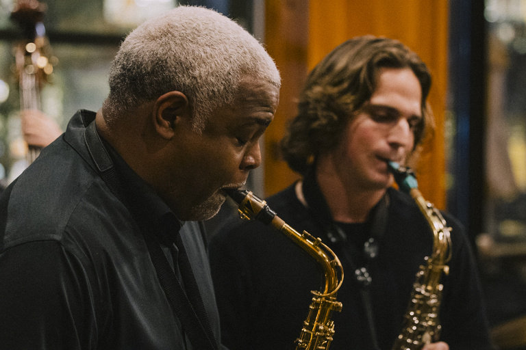 Damani Phillips plays saxophone alongside a student musician