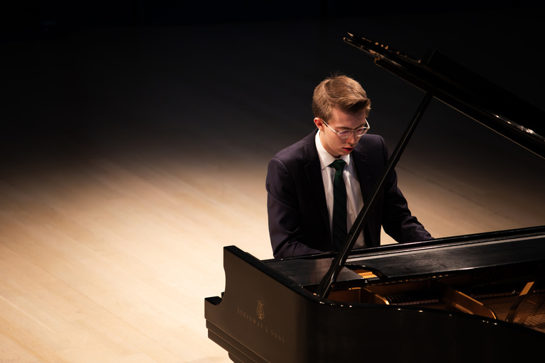 young pianist playing grand piano