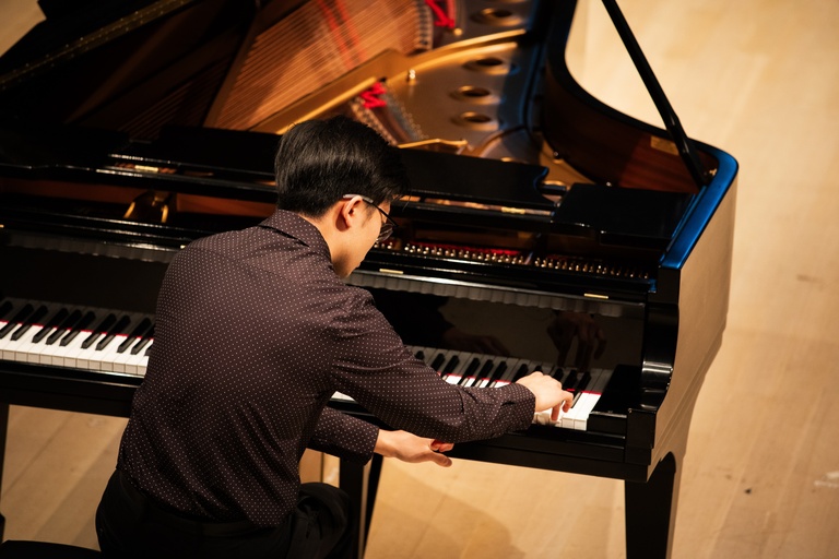 person playing piano on stage at Voxman Concert Hall