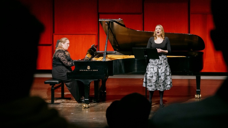pianist performing with vocalist in recital hall