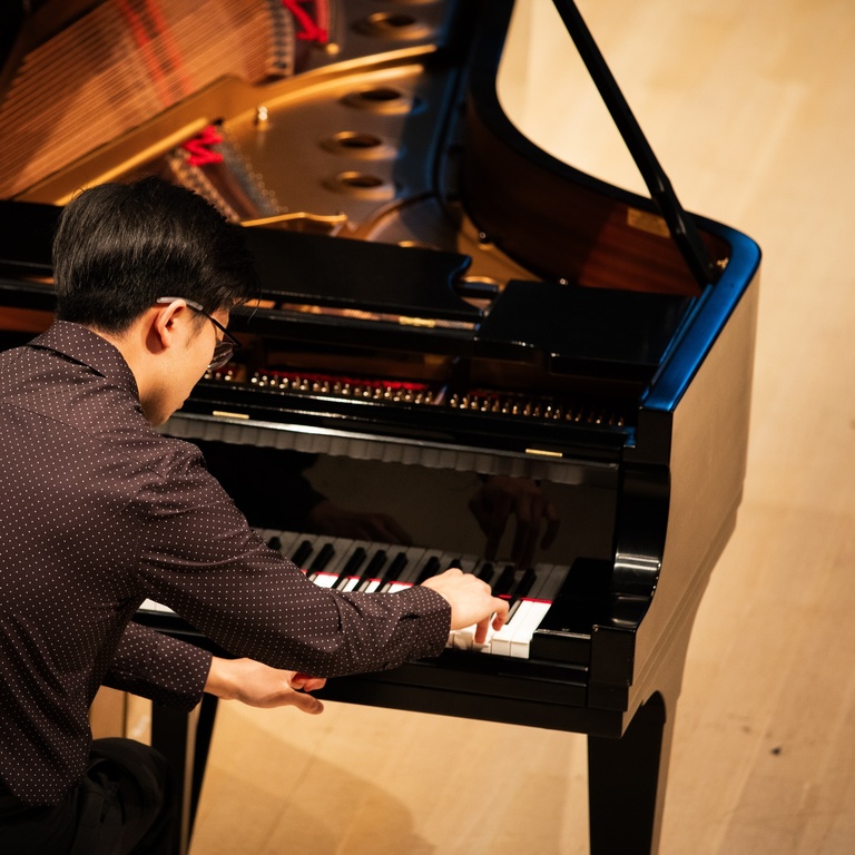 person playing piano on stage at Voxman Concert Hall
