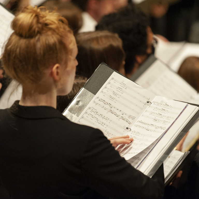 UI Choral student reading sheet music and singing