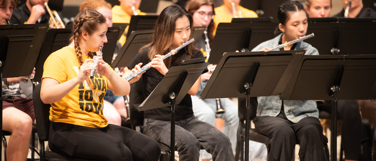 Flute section at a Symphony Band rehersal, where students playing the flute are dressed in Hawkeye Black and Gold 