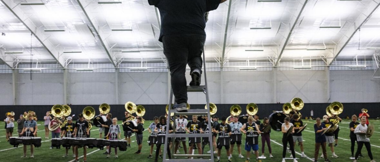 Graduate teaching assistant and doctoral student Drew Bonner conducts Oct. 26 during a Hawkeye Marching Band practice at the Hawkeye Tennis and Recreation Complex in Iowa City. (Nick Rohlman/The Gazette)