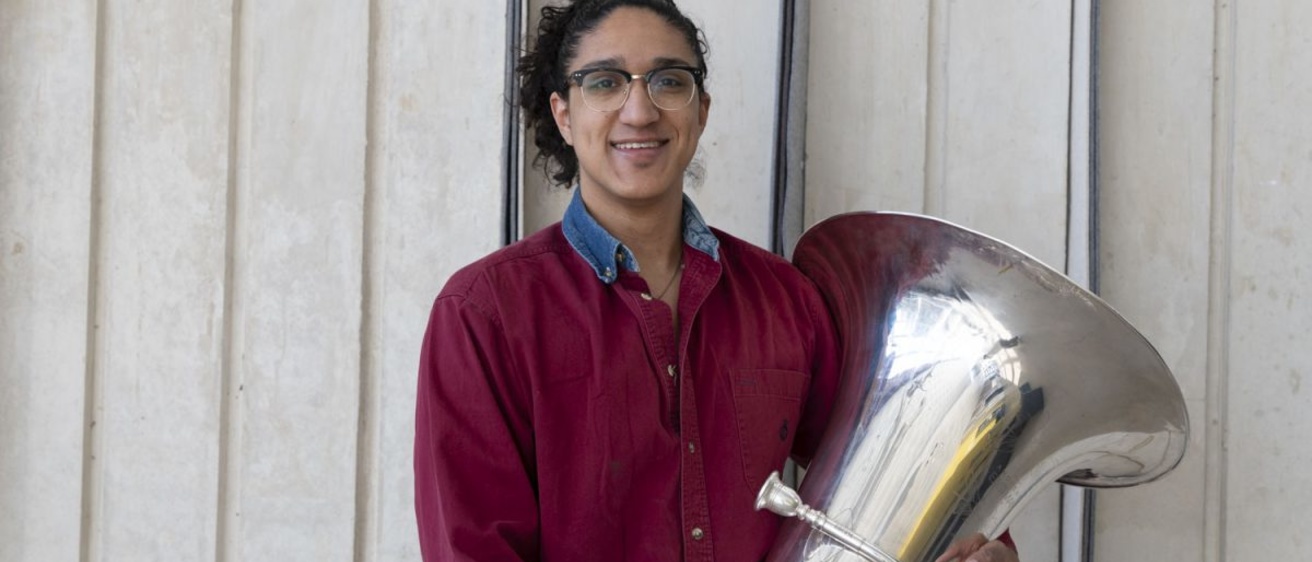 John Reyna, a graduate teaching assistant and tubist, poses for a photo in the Voxman Music Building on Friday, March 29, 2024. Reyna has previously had musician’s dystonia. Musician’s dystonia is a movement disorder that results in a loss of voluntary motor control in extensively trained movements.