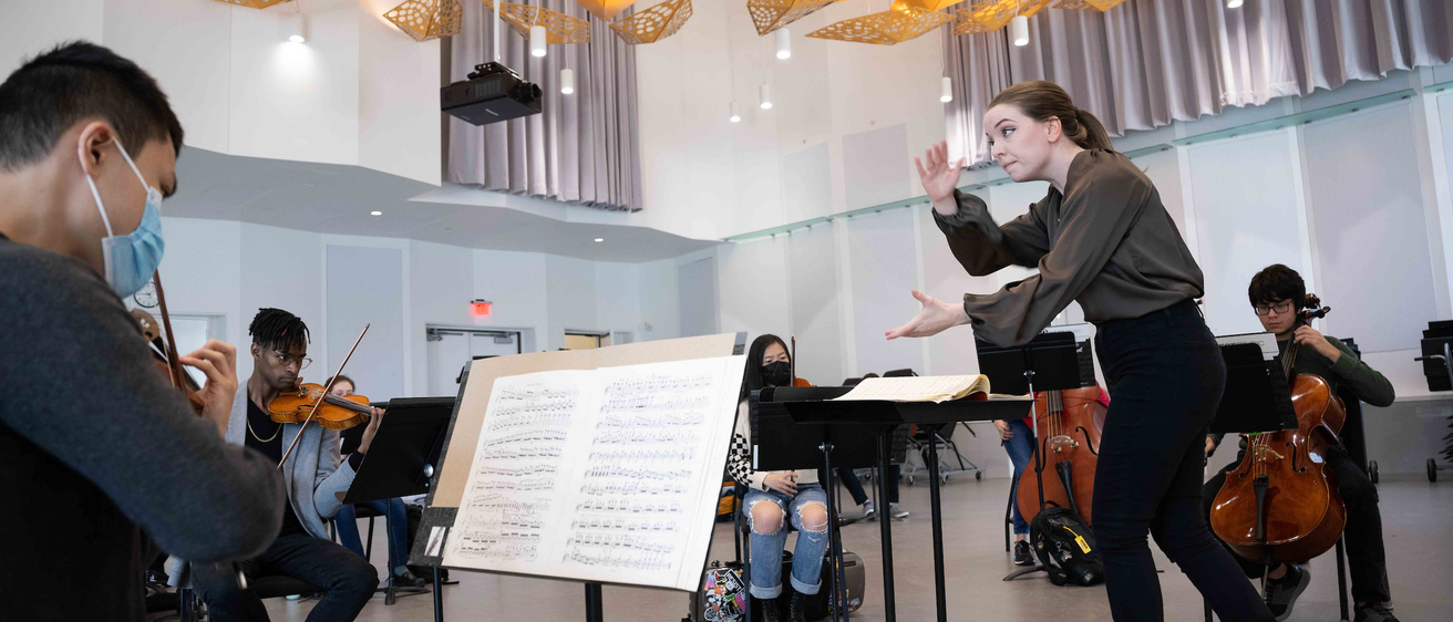 Megan Maddaleno conducting students in Voxman Music Building