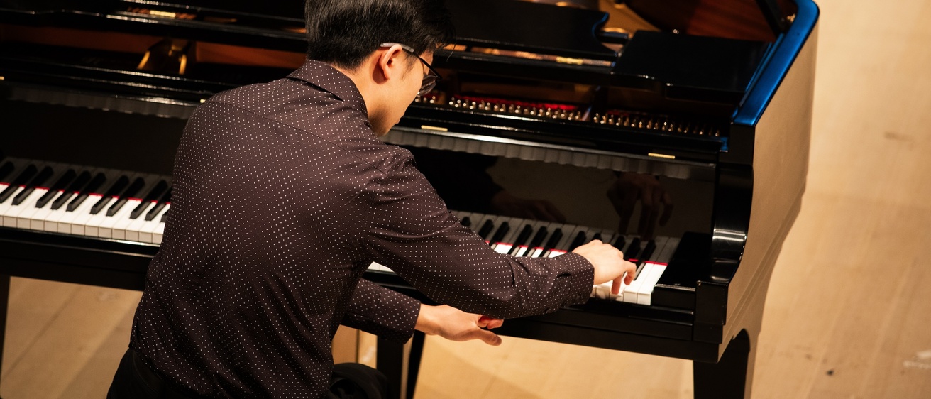person playing piano on stage at Voxman Concert Hall