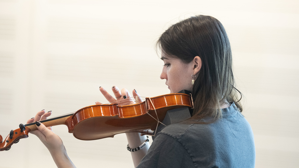 student musician plucking the strings of her instrument