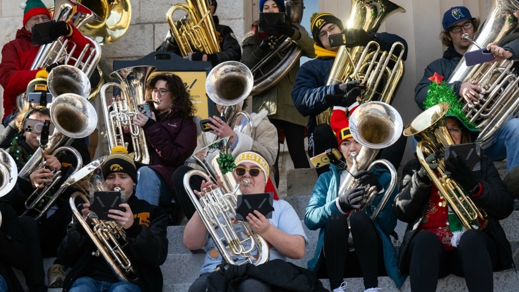 low brass musicians in festive holiday wear playing their instruments on the steps of the Old Capitol