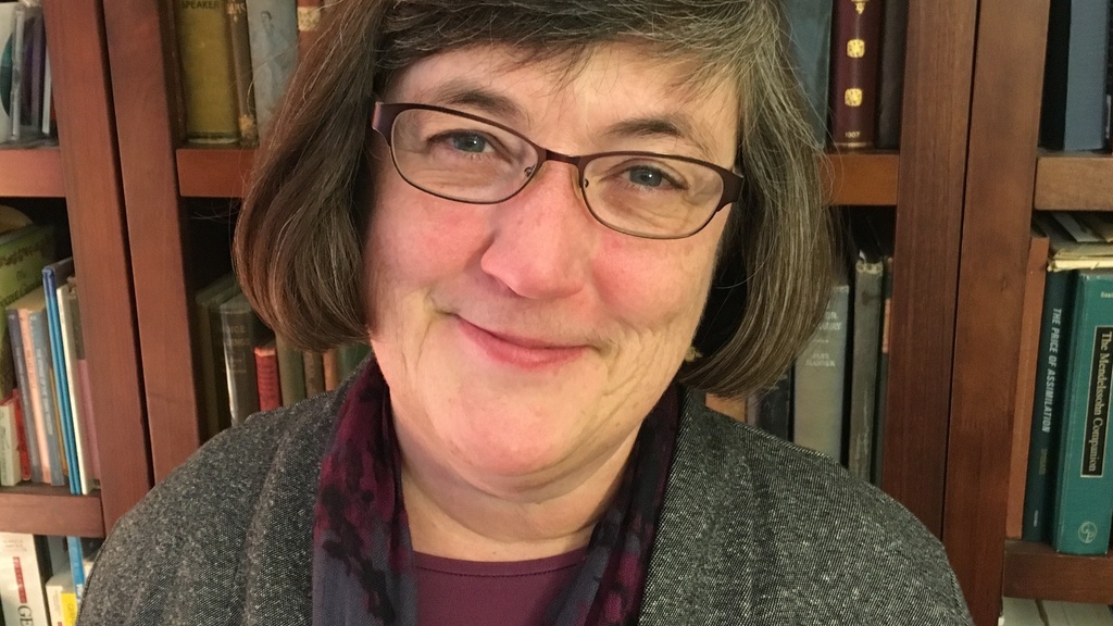 Marian Wilson Kimber, pictured smiling in front of a bookshelf full of books