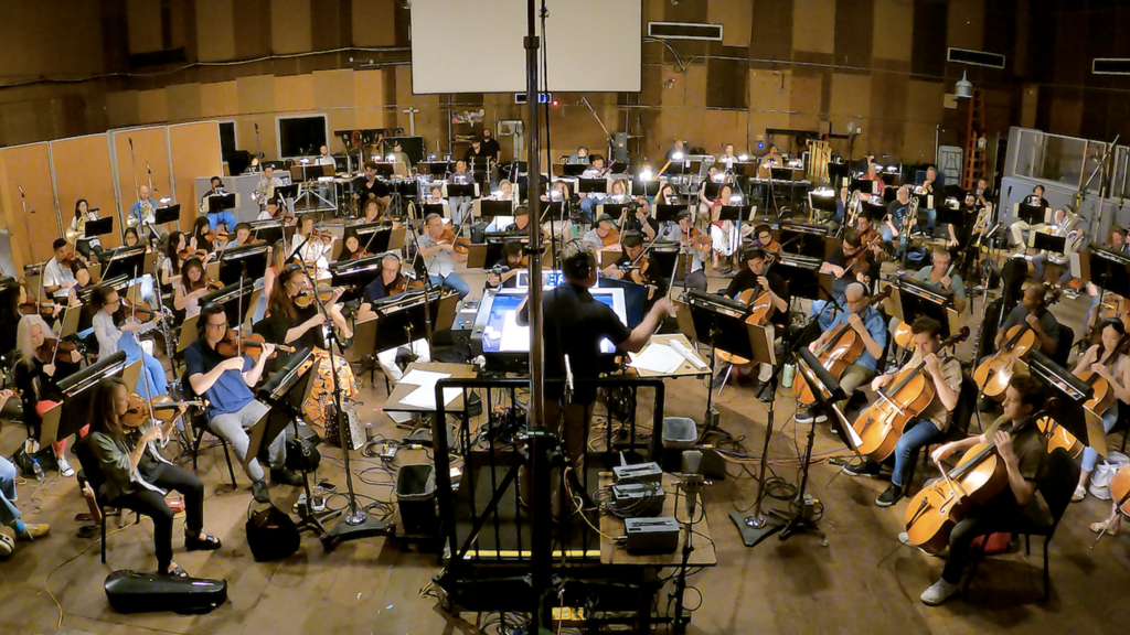 University of Iowa alumnus Scott Icenogle conducts an 85-piece orchestra for the first recording of his original composition, Ode to Voxman.  